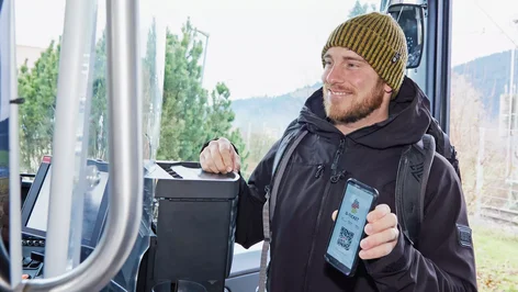 Mann zeigt beim Fahrer Ticket auf dem Smartphone vor