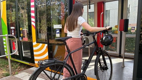 Person steigt mit Fahrrad in Stadtbahn ein