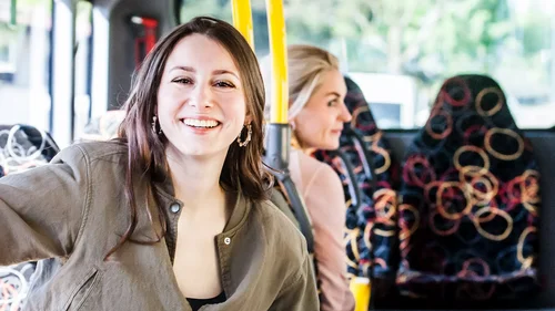 Lachende Frau in öffentlichem Verkehrsmittel