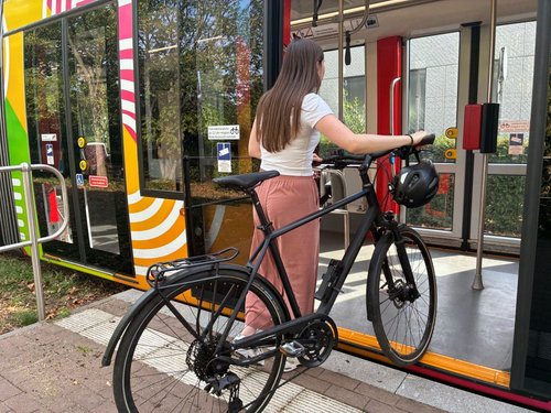 Person steigt mit Fahrrad in Stadtbahn ein