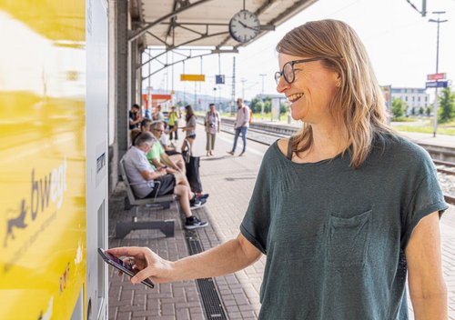 Frau an Fahrscheinautomat