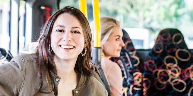 Lachende Frau in öffentlichem Verkehrsmittel